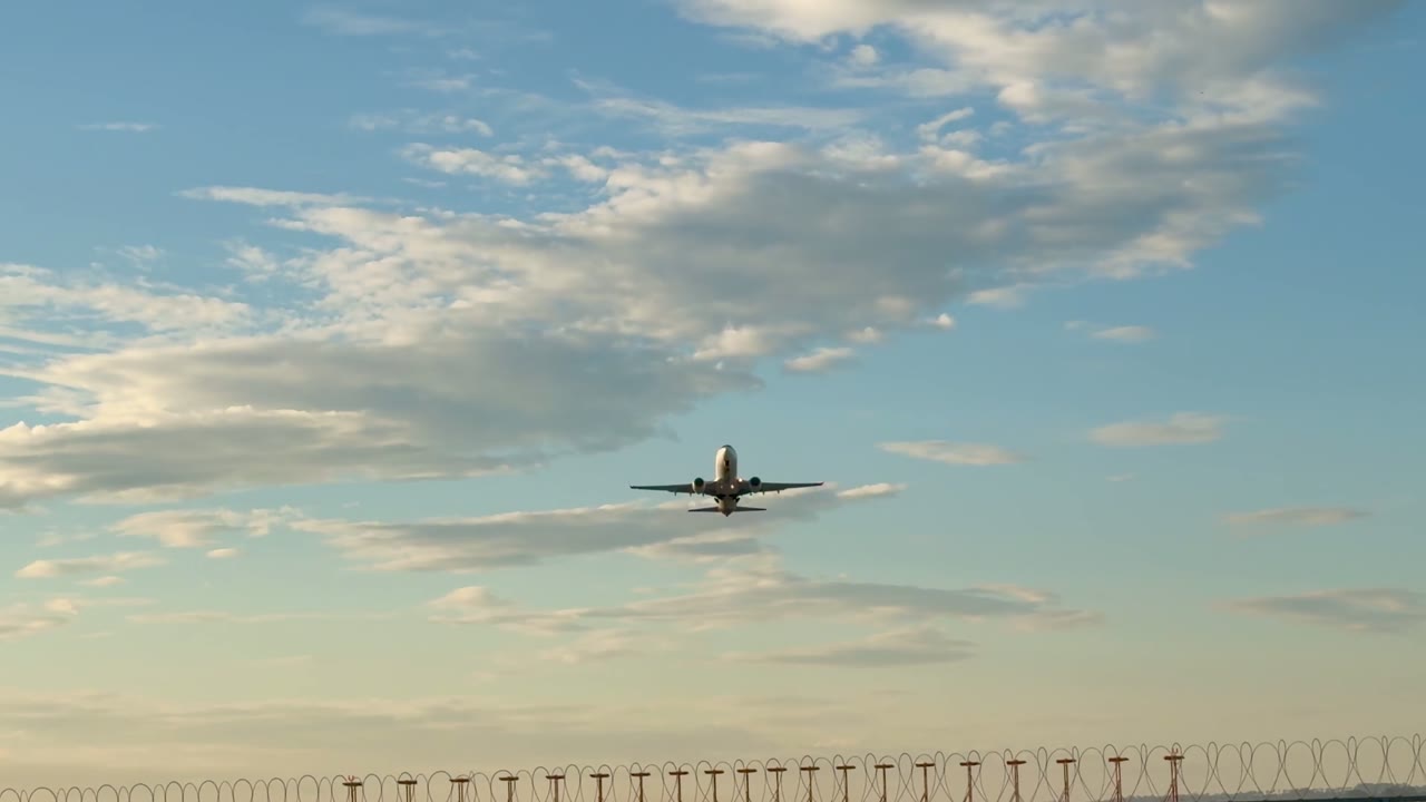 Commercial airliner taking off into a golden sky